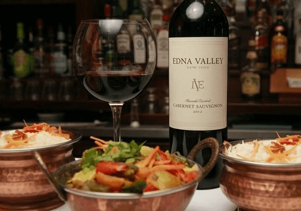Concept: curry bowls and wine at the bar, dark studio lighting