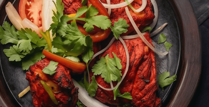 Concept: tandoori chicken tikka, dark studio lighting