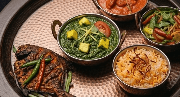 Concept: thali tray with tandoori fish and naan, dark studio lighting